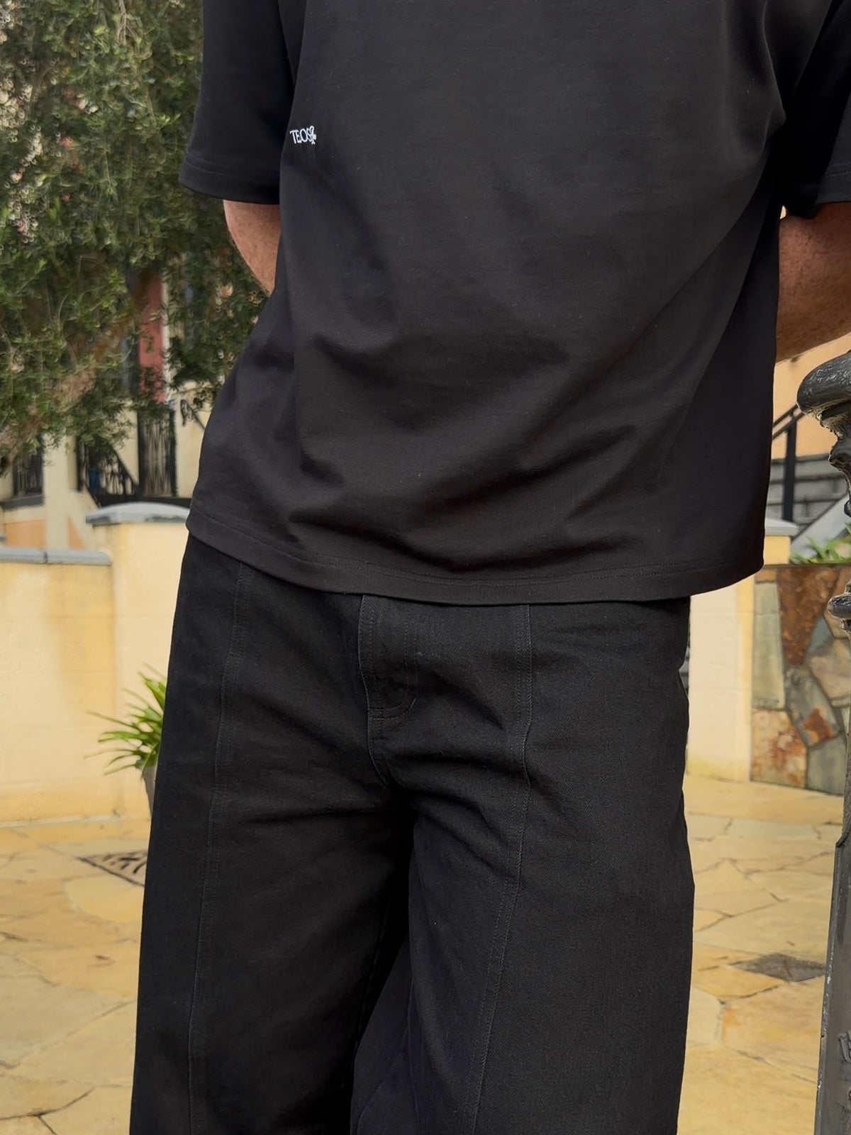 Model wearing the Telos Rae Box Tee in black, organic cotton