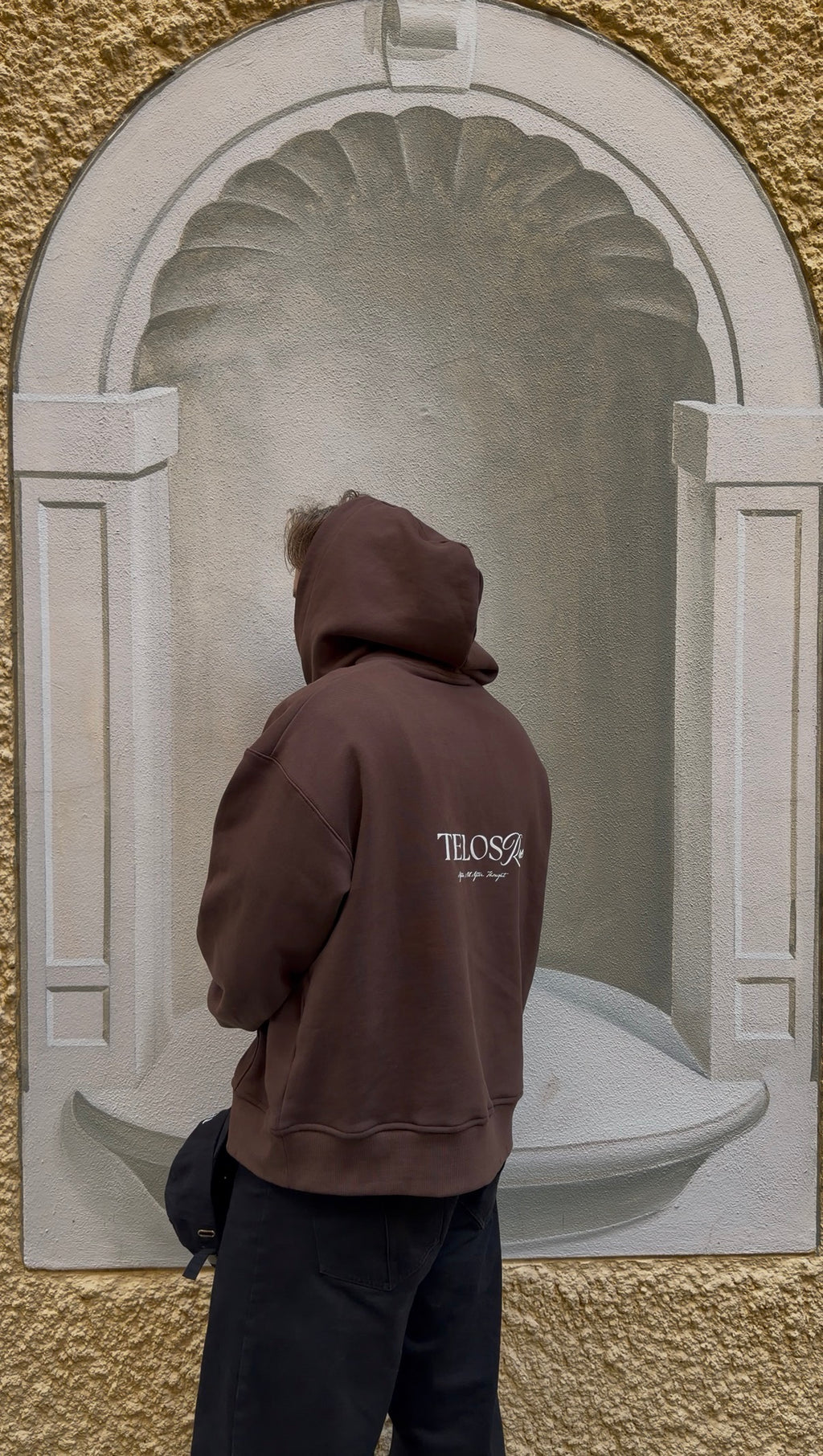 Model wearing the Telos Rae Box Hoodie in espresso brown